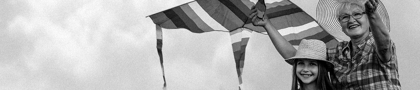 A grandmother and her daughter enjoying a moment together while flying a kite with USAble Life insurance plans